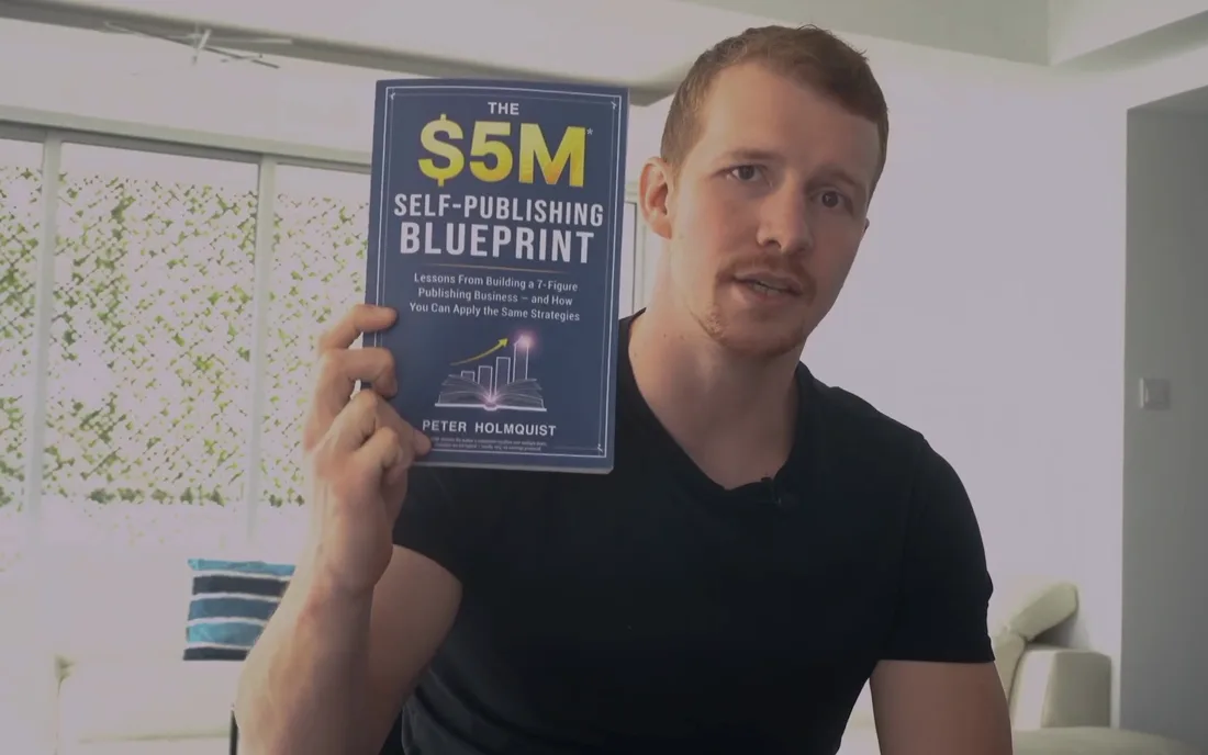 Peter Holmquist holding his book, The $5M Self-Publishing Blueprint